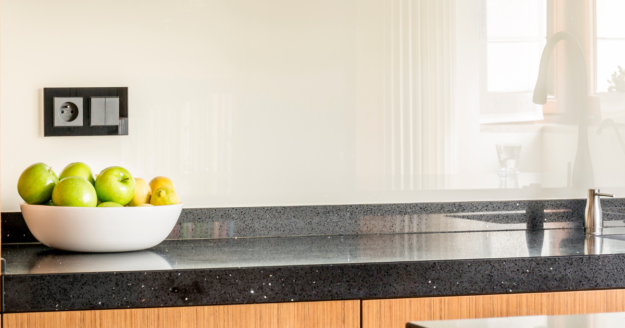 Quali sono i migliori materiali per il piano da lavoro della tua cucina? Questa è una domanda cruciale per chiunque ami trascorrere del tempo nella cucina e stia cercando la cucina perfetta. Oltre all'aspetto estetico, è importante considerare la resistenza al calore, agli urti e la facilità di pulizia. Come scegliere il miglior top per cucina. Guida completa per valutare il miglior piano da lavoro per cucina La scelta del materiale del piano cucina deve dipendere dalle tue abitudini culinarie, dalle tue esigenze personali e dal tempo che hai a disposizione. Prima di tutto, devi decidere cosa è più importante per te: la resistenza, l'aspetto, l'innovazione o l'igiene? Se prevedi di utilizzare molto la cucina, magari a causa di una famiglia numerosa o della tua passione per la cucina, allora dovresti optare per materiali resistenti. Tuttavia, molti di questi materiali robusti possono anche offrire un impatto visivo notevole, se abbinati con attenzione al resto dell'arredamento della cucina. Migliori top per cucina. Ecco alcune opzioni da considerare quando si deve scegliere il top per la cucina. Top in Quarzo: Questi piani cucina uniscono l'estetica alla robustezza. Sono disponibili in una vasta gamma di varianti di colore, opacità e brillantezza, e sono realizzati a partire dalla pietra naturale, polverizzata e riamalgamata, per ottenere una superficie lucida come la pietra. Nonostante la somiglianza con graniti e marmi, il quarzo non è poroso e non assorbe i liquidi, ma è sensibile agli shock termici. Pietre Naturali (Marmo o Granito): Il marmo offre una grande versatilità estetica con una gamma infinita di colori e venature, ma è poroso e può macchiarsi facilmente. Il granito è altamente resistente a urti e graffi ed è meno suscettibile alle macchie grazie alla sua superficie irregolare. Corian: Questo materiale innovativo offre una vasta possibilità di personalizzazione in termini di colore e forma ed è resistente a urti, macchie e graffi. È anche facile da pulire, ma non è altamente resistente alle temperature estreme. HPL: Anche se è un laminato, l'High-pressure decorative laminate è molto resistente grazie al processo di produzione che coinvolge strati di fibre di cellulosa impregnati con resine termoindurenti. Resiste praticamente a tutti gli stress derivati dall'uso quotidiano. Pietre Sinterizzate (Dekton, Lapitec o Neolith): Questi materiali offrono resistenza, stabilità termica, e proprietà igieniche. Sono costosi ma adatti a chi cerca il massimo della qualità. Vetro Temperato: Il vetro temperato è resistente, facile da pulire e dona un aspetto raffinato alla cucina. Tuttavia, è delicato agli urti e ai graffi. Fenix: Questo materiale si rigenera con il calore ed è altamente personalizzabile in termini di forma e colore. È anche igienico, antistatico e facile da pulire. Acciaio: L'acciaio è estremamente igienico ma può graffiarsi facilmente ed è più adatto a cucine moderne. Laminato: Questo materiale offre un buon rapporto qualità-prezzo ma non è altamente resistente alle alte temperature e all'umidità.